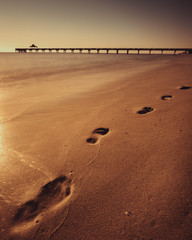 Vertical longexposure photo of pier with sand footsteps, Deerfield beach, Florida
