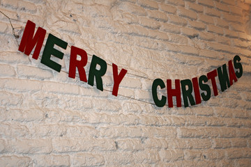  Merry Christmas lettering hanging on white wall