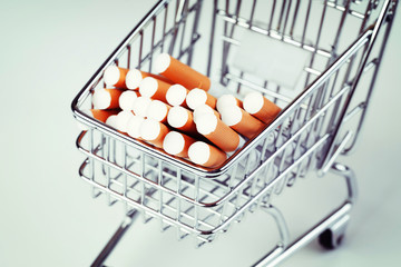 Cost of cigarettes concept. Cigarettes shopping cart