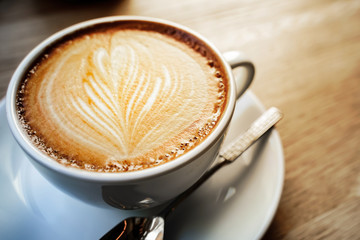 cup of the latte art coffee with warm light