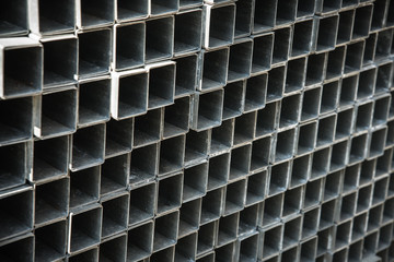 Square metal pipes stacked for sale.