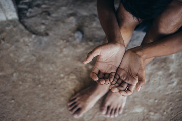 hands poor child or beggar begging you for help sitting at dirty slum. concept for poverty or...