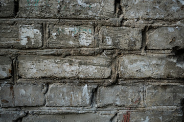 Texture of an old paint covered brick wall. Background image of an abandoned brick wall with painted over paint