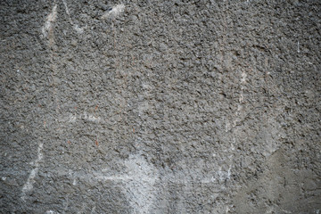 Texture of an old cracked concrete wall. Background image of a worn gray concrete surface