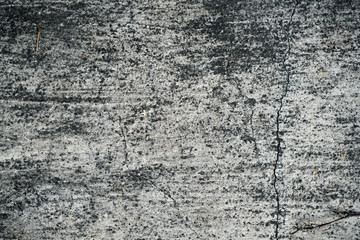 Texture of an old cracked concrete wall. Background image of a worn gray concrete surface