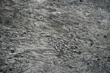 Texture of an old cracked concrete wall. Background image of a worn gray concrete surface
