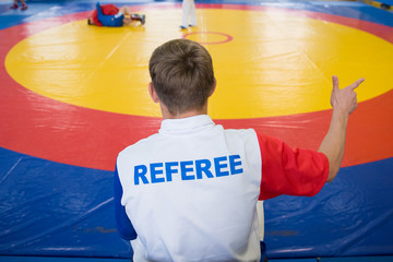 Referee shows one point to athlete in red
