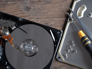 The old IDE hard disk internal components with a beautiful shiny magnetic disk.