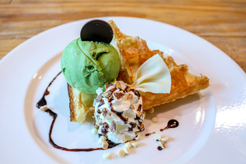 dessert made of brownie and green tea ice cream together with whipped cream on the white plate