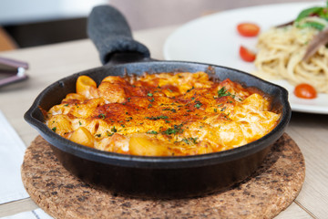 Baked macaroni and cheese with fresh tomato sauce served on hot pan