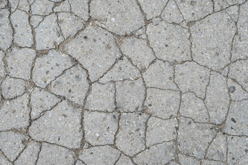 Old road background - surface of grey cracked asphalt texture