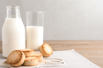 Tasty homemade cookies and milk on wooden table. Space for text