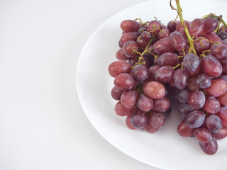 Bunch of grapes on white plate.