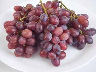 Bunch of grapes on white plate.