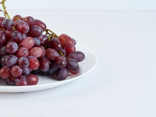 Bunch of grapes on white plate.