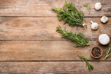 Flat lay composition with fresh rosemary on wooden table. Space for text