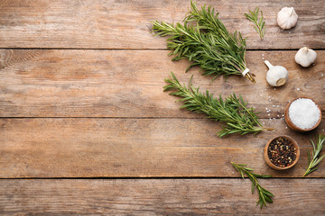 Flat lay composition with fresh rosemary on wooden table. Space for text