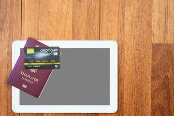 Top view Passport with credit card and digital tablet mock up on wooden desk