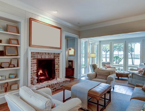 Beautiful living room with fireplace and blank picture frame. Place your own artwork over the mantle.