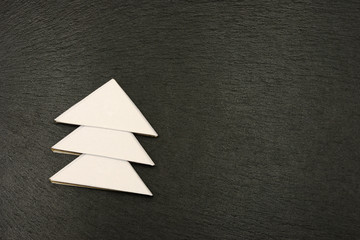 white christmas tree  lying on black shale at christmas time