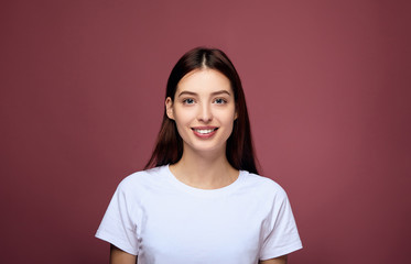 Nice girl in a white T-shirt smiles affably.