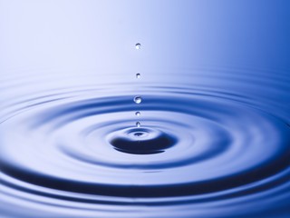 Naklejka na ściany i meble Drops hitting surface of water close-up