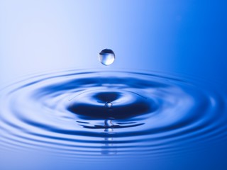 Drop hitting surface of water close-up