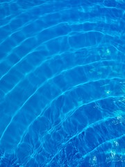 Fototapeta na wymiar Rippled blue water in swimming pool view from above