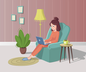 Young woman is sitting in armchair with laptop and cup of coffee or tea. Cozy interior with plant, floor lamp, carpet and pictures.