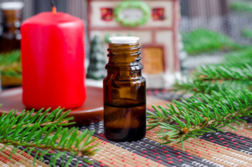 Small bottle with essential fir oil and fir tree branches. Christmas aromatherapy. Winter spa and herbal medicine ingredients. Copy space