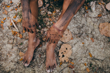 poor child or beggar begging you for help sitting at dirty slum. concept for poverty or hunger people,human rights,donate and charity for underprivileged children in third world 