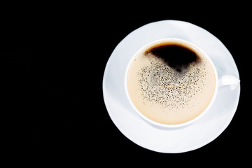 black coffee pour into a white mug on a dark background