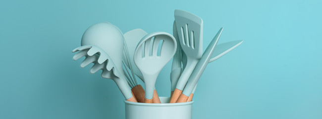 Kitchen utensils background with copyspace, home kitchen decor concept, kitchen tools, rubber accessories in container. Restaurant, cooking, culinary, kitchen theme. Silicone spatulas and brushes