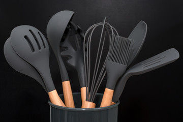 Kitchen utensils background with copyspace, home kitchen decor concept, black kitchen tools, rubber accessories in container.Restaurant, cooking, culinary, kitchen theme. Silicone spatulas and brushes