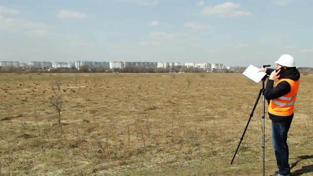 Surveyor worker measures the distance and length using measuring equipment for the construction of a new micro district, copy space