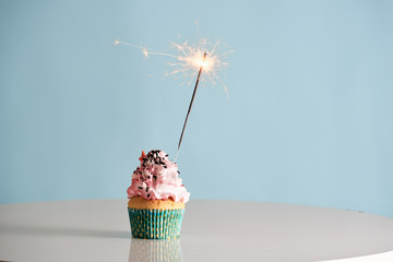 Single sparkler on cupcake blue wal