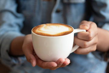hand hold coffee latte on coffee shop