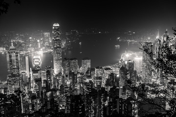 Victoria Harbour skyline by night from Lugard Road Lookout at Victoria Peak, the highest mountain in Hong Kong Island. Panorama of skyscrapers and towers of Hong Kong in black and white. - 310676720