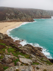 Wide vertical view of a sandy bay beach along the coastal granite cliffs of Porthcurno. Conrwall, United Kingdom. Travel and tourism. - 310677330
