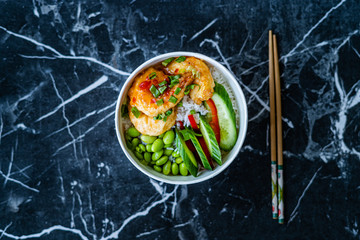 Take Away Healthy Buddha Bowl with Shrimp, Edamame Beans, Cucumber and Basmati Rice / Poke Bowl in Plastic Box Package or Container.