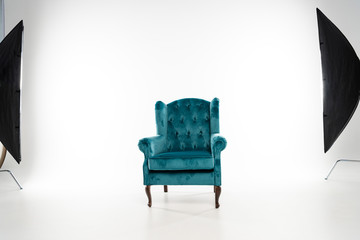 Turquoise armchair with studio light on white background