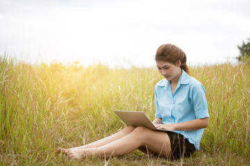 Attractive young woman  with laptop working on park. Freedom, remote work, freelancer, technology, internet, travel and vacation concepts