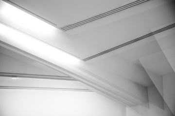 Computer graphics of abstract architecture fragment. Modern office building interior with polygonal white concrete girder elements of ceiling. Diagonal geometric composition in light gray color.