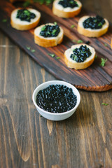 White bowl with the black caviar inside it.