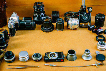 Retro mockup, vintage photographic accessories and quipments around on wooden Background. Top view