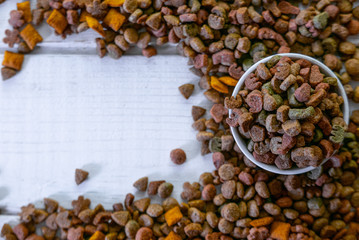 Top view of colorful dry pet food in a white ceramic bowl