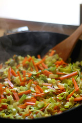 Carrot, leek and pumpkin, stir frying in a wok. Selective focus.