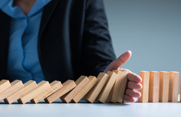Risk management Businesswoman stop domino effect. leadership has solution for problem.