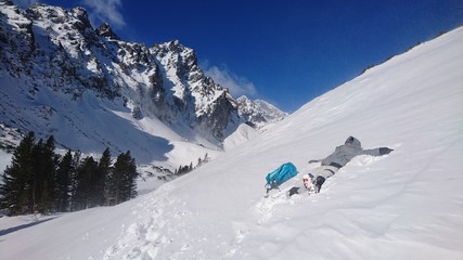 Hiker lying in the thick snow mountain winter relaxation backpack high tatra rocky mountains