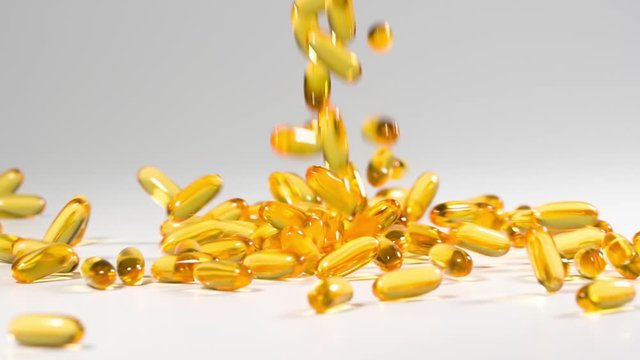 Vitamins and supplements fall onto a white surface in slow motion